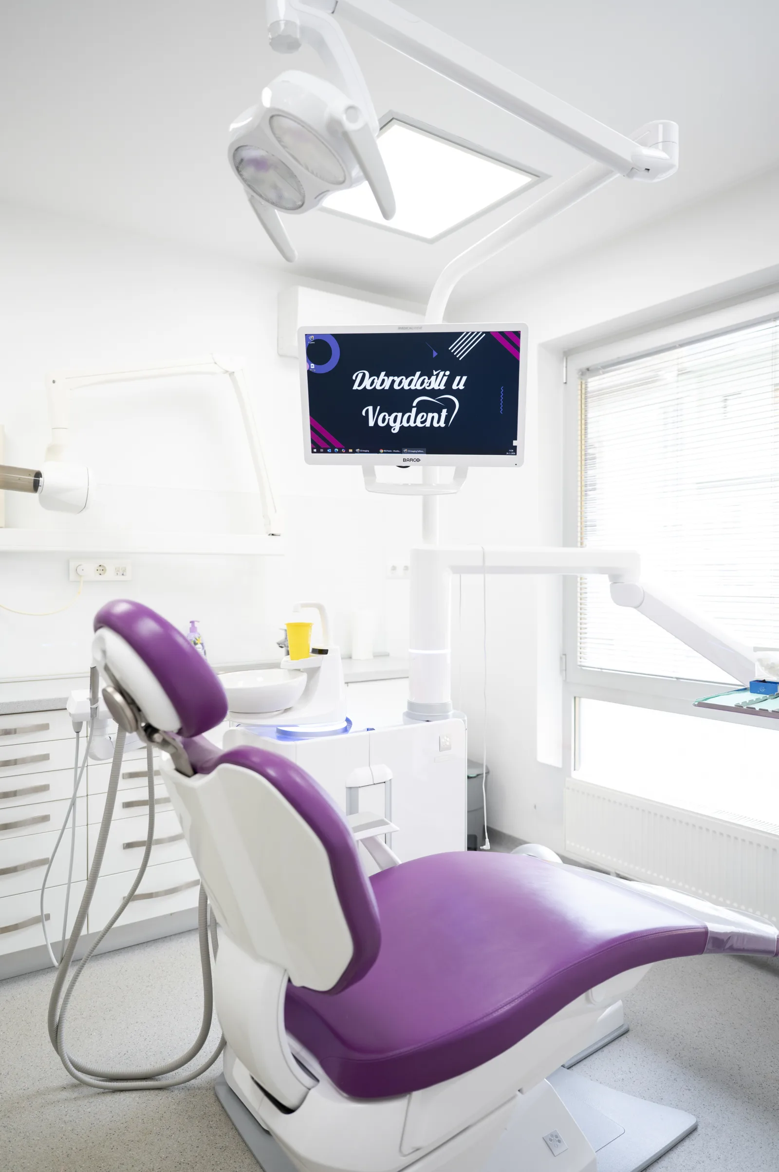 Ordinacija Vogdent — prazan tretmanski prostor; monitor: Dobrodošli u Vogdent